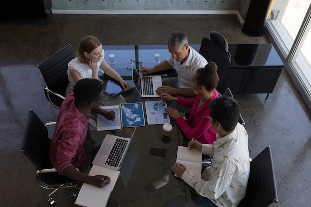 A group of diverse professionals collaborating around a table, using laptops and discussing data, illustrating the importance of teamwork and technical skills in an AI-driven workplace.